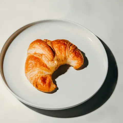 Butter croissant on a white plate